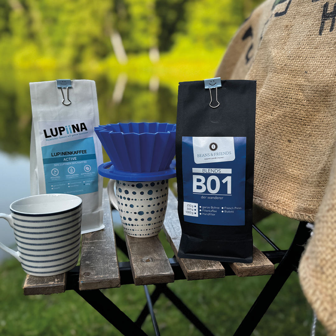 „Auf einem Holzstuhl mit einem Kaffeesack, im Hintergrund Grün, Gelb und viel Wasser, zeigen wir eine Gelegenheit, wie man unterwegs draußen den Kaffee einfach und schnell mit einem blauen Origami-Handfilter direkt in eine Tasse aufgießen kann – nur eine von vielen Möglichkeiten, natürlich und pur zu genießen.“