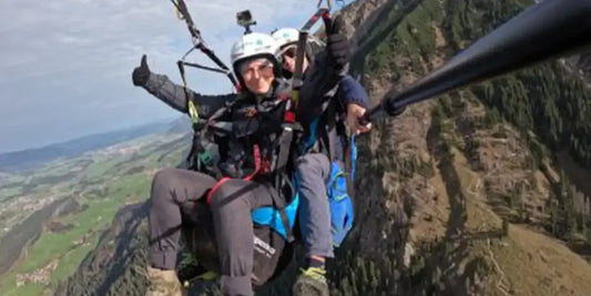 Tina beim Paragliding über den Bergen von Oberstdorf.