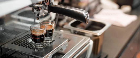 zwei Espressogläser werden gerade mit einer Siebträger Espressomaschine gefüllt