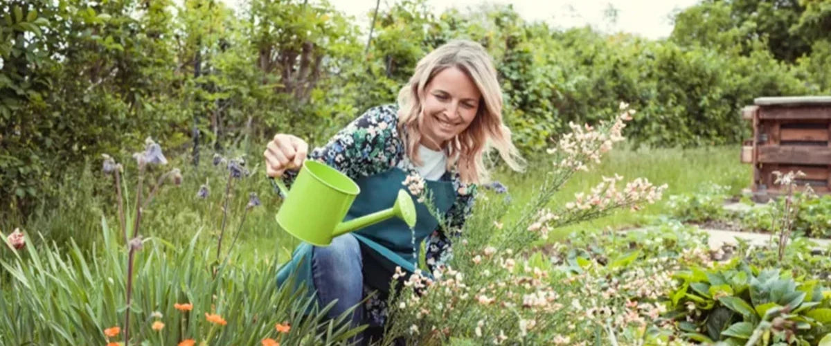 Frau bei der Gartenarbeit mit natürlichem Kaffeedünger im grünen Garten.