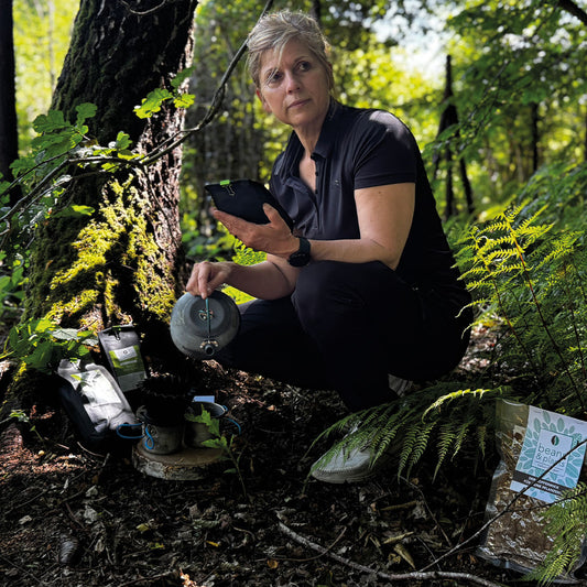 „Tina im Wald, umgeben von der grünen Ruhe der Natur, brüht sich mit einer nostalgischen Kanne ihren Waldkaffee aus der Serie Land- und Waldkaffees auf. Fasziniert von der Umgebung, genießt sie den Moment in vollen Zügen.“
