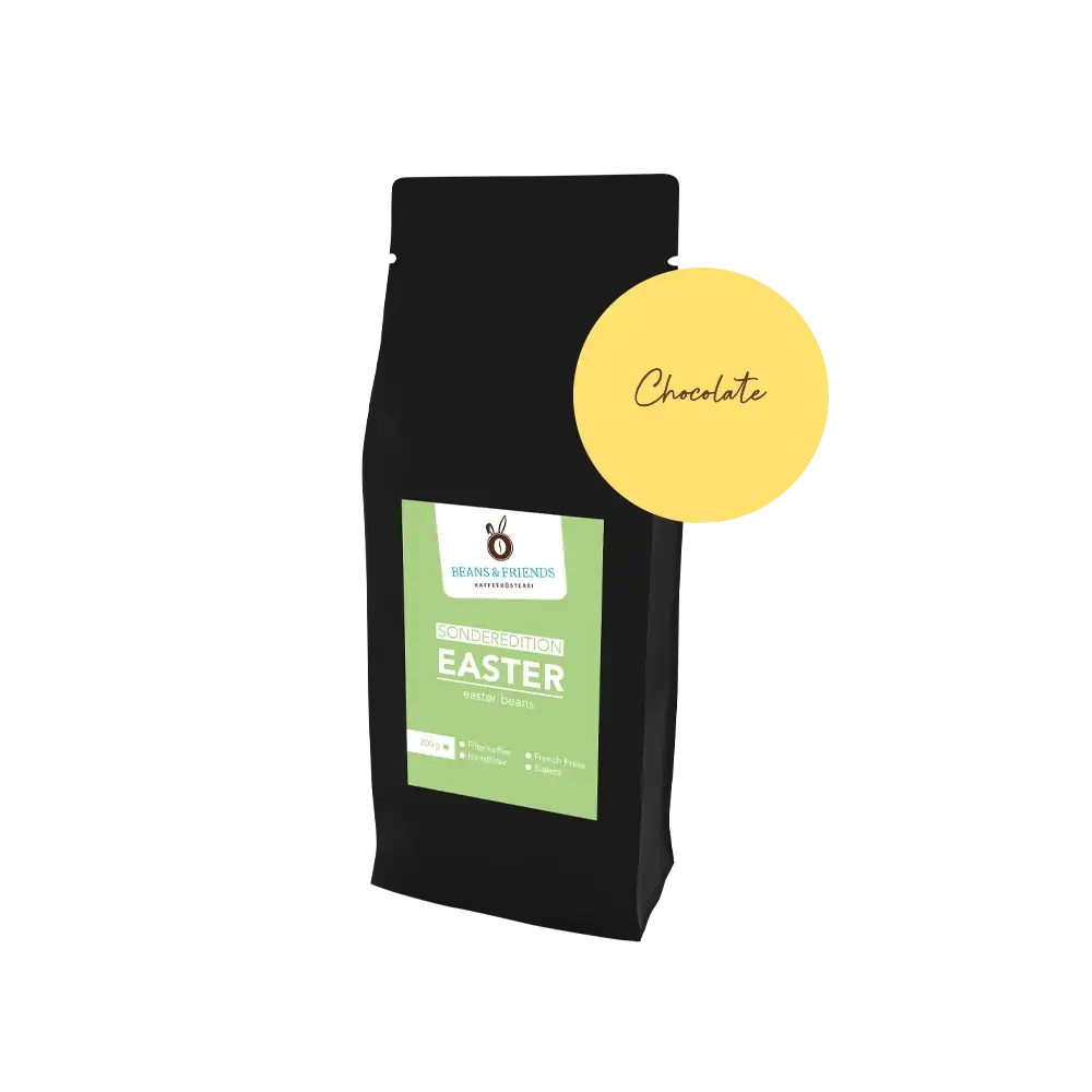 Easter Coffee Chocolate – Edle schwarze Verpackung mit frühlingshaftem grünen Etikett und runder  gelber Aufkleber, der die Geschmacksrichtung der Sorte anzeigt. 