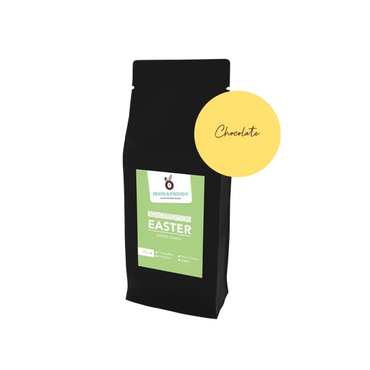 Easter Coffee Chocolate – Edle schwarze Verpackung mit frühlingshaftem grünen Etikett und runder  gelber Aufkleber, der die Geschmacksrichtung der Sorte anzeigt. 